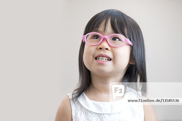 Junges Mädchen mit rosa Brille  Studioaufnahme.