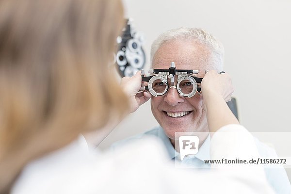 Optiker testet die Sehkraft eines Mannes.