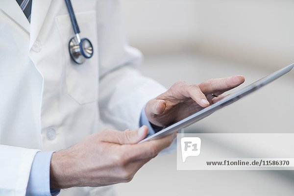 Männlicher Arzt mit digitalem Tablet.