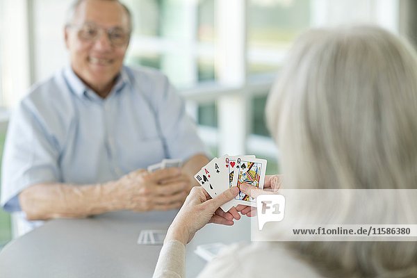 Ein älteres Paar spielt Karten.