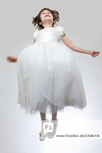 Mädchen in weißem Kleid  springend