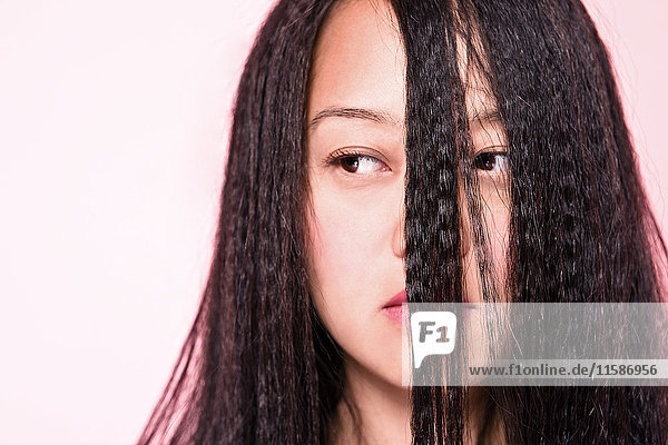 Woman with crimped hair covering face