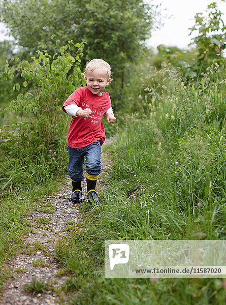 Toddler boy running on dirt path