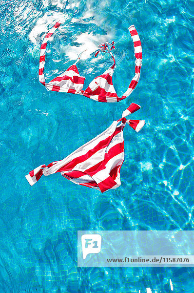 Rot-weiß gestreifter Bikini schwimmt auf der Wasseroberfläche
