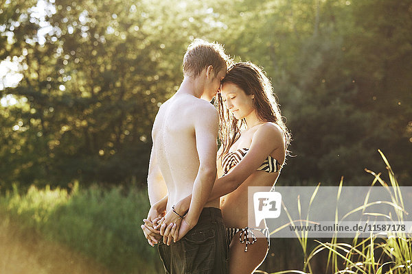 Young couple embracing at river