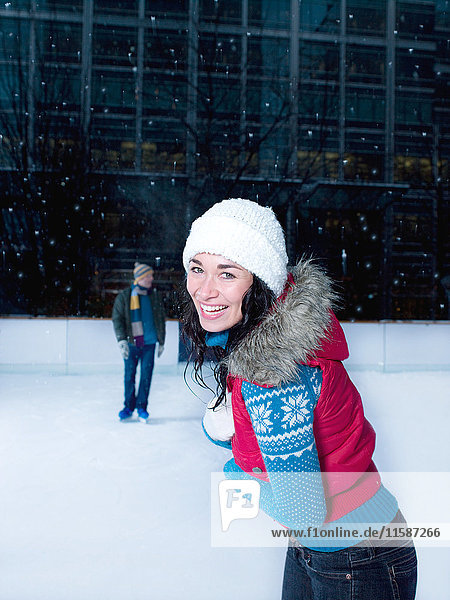 Woman skating on an ice rink in the snow