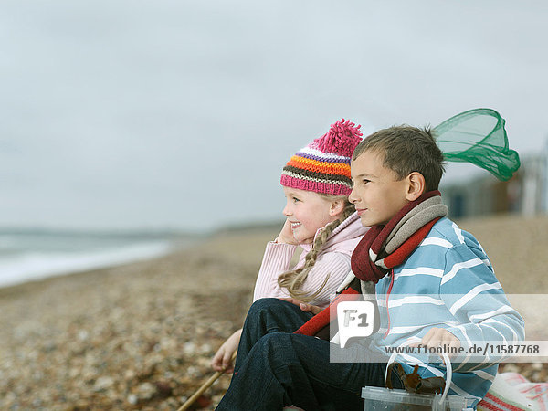 Junge und Mädchen am Strand mit Blick aufs Meer