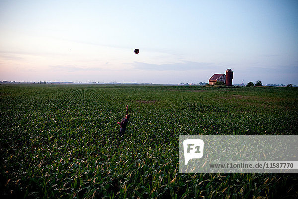 Landwirt wirft Hut auf dem Feld in die Luft
