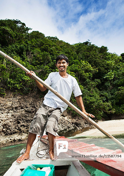 Man rowing boat in tropical waters