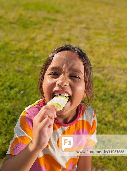 Girl biting into ice lolly  portrait