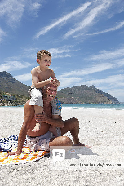 Older man with grandson on beach