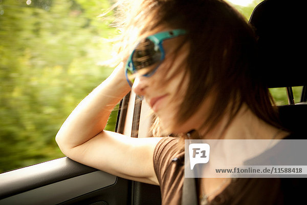 Weiblicher Passagier im Auto mit geöffnetem Fenster