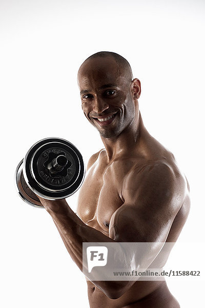 Smiling bare chested man lifting weights