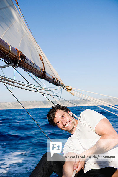 man smiling steering a sailing boat