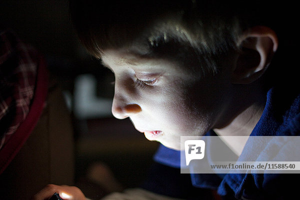Young boy with face illuminated by light