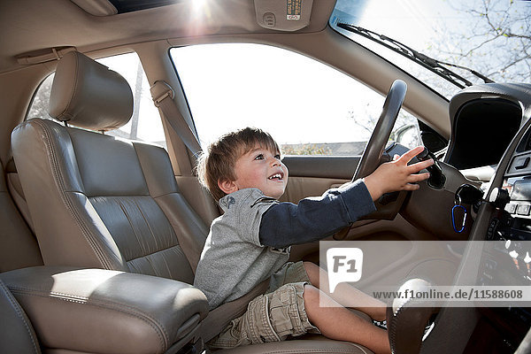 Kleiner Junge  der vorgibt  Auto zu fahren