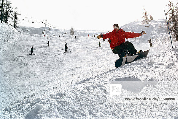 Männlich in Aktion auf einem Snowboard