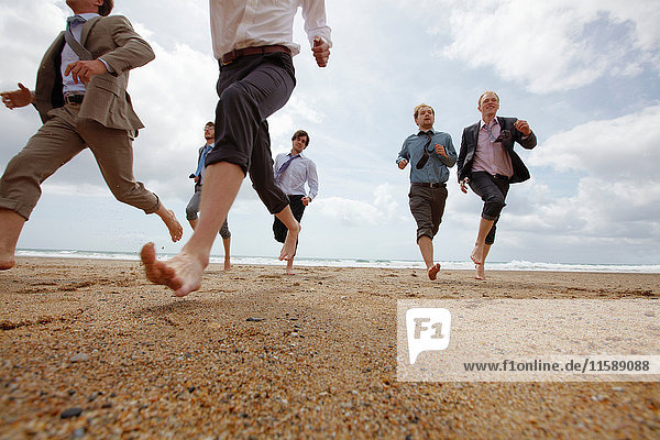 Businessmen running on beach