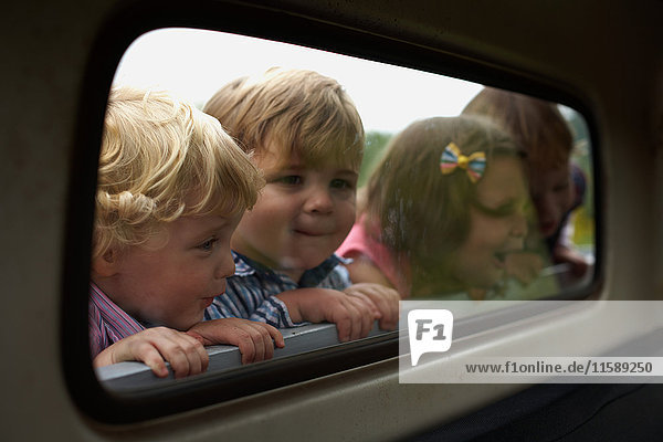 Four children peering through truck window