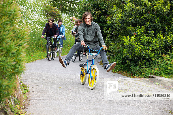 Teenagers riding bicycles in park