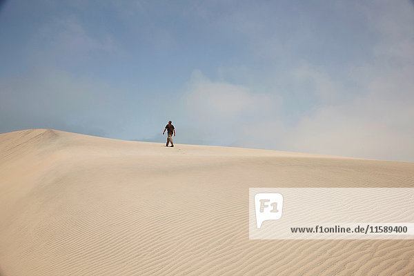 Man walking on sand dunes