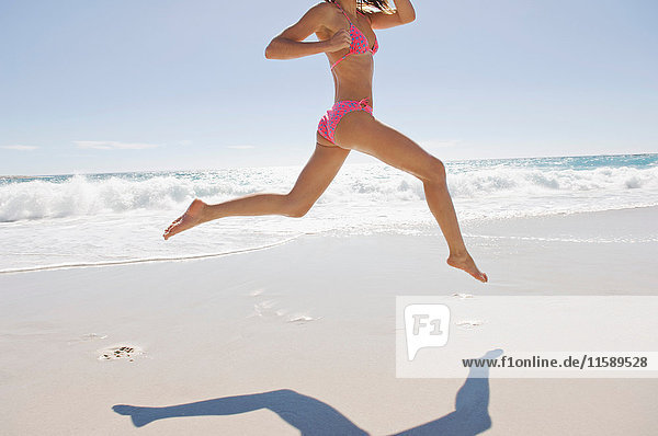 Ein Mädchen springt über den Strand
