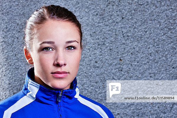Portrait of young woman wearing blue tracksuit top