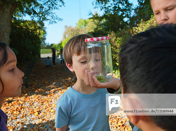 Boy showing jar to children