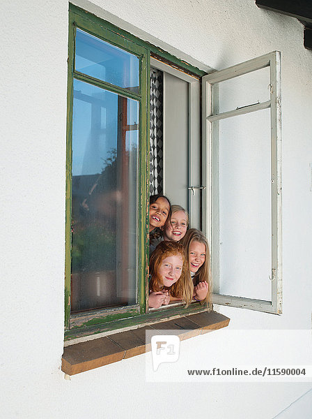 Girls looking through open window  portrait