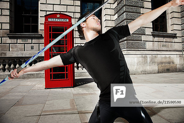 Javelin thrower with red telephone box in background
