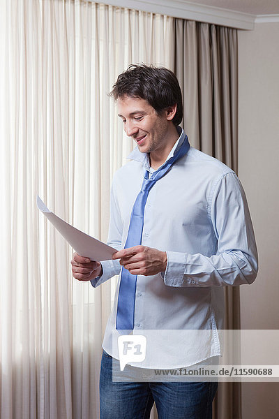 Mann mit Papier in der Hand Lesen Morgen