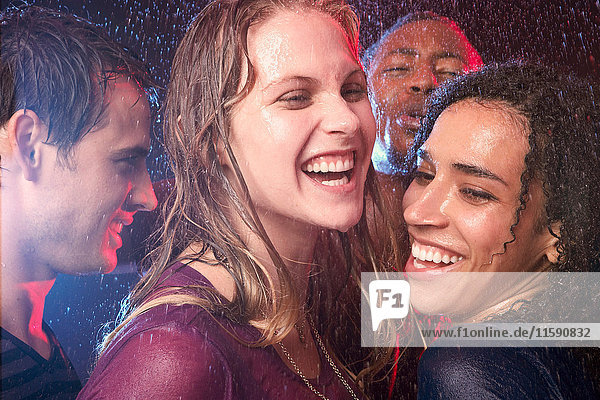 Eine Schar von Freunden tanzt im Regen