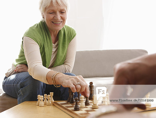 Senior couple playing chess at home