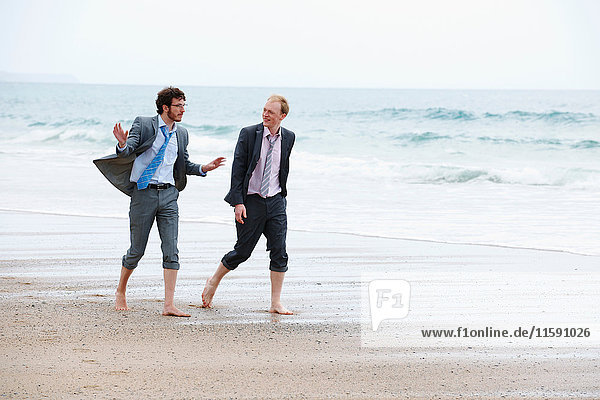 Businessmen walking on beach