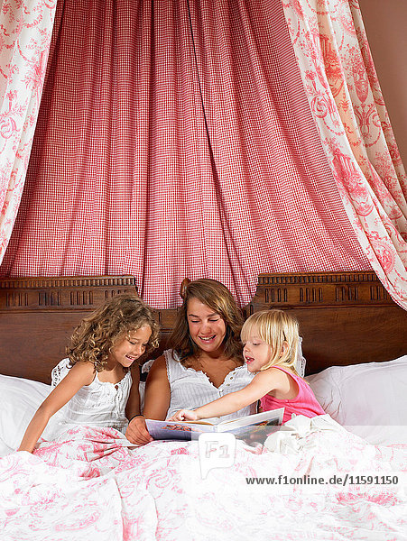 Girls reading a book in bed