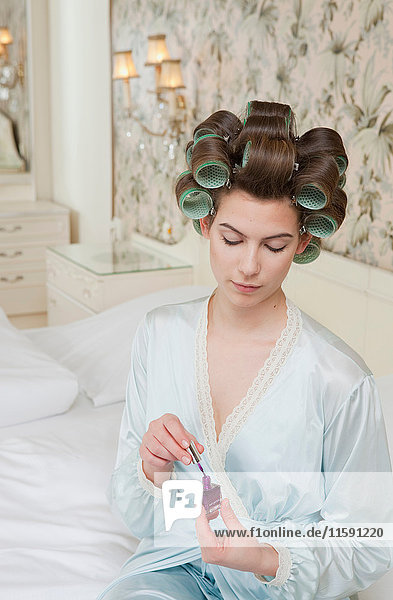junge Frau mit Nagellack auf dem Bett