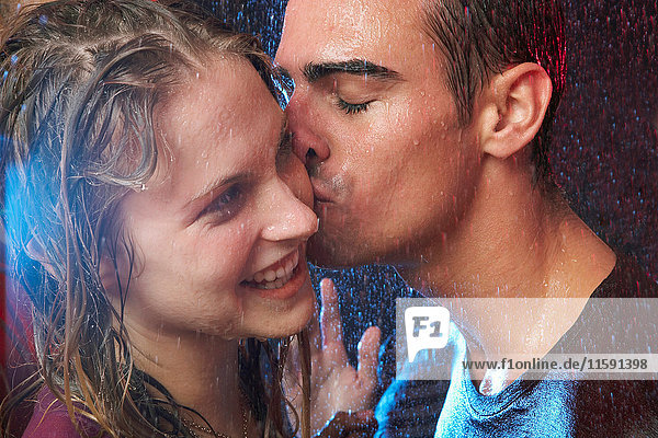 Junges Paar küsst sich im Regen