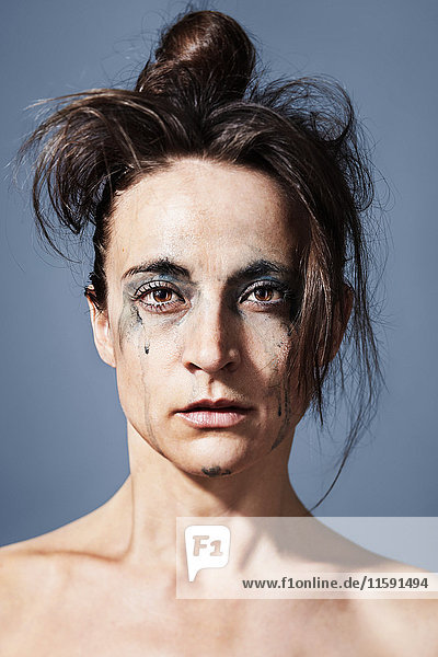 Porträt einer weinenden Frau mit über das Gesicht laufender Schminke