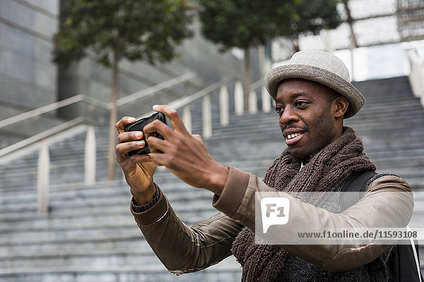 Lächelnder Mann nimmt Selfie mit Smartphone