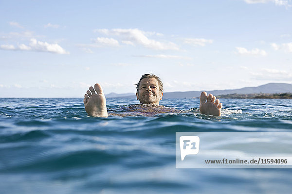 Relaxed mature man floating in the sea
