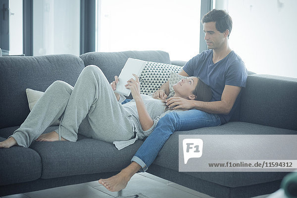 Young couple with tablet relaxing at home