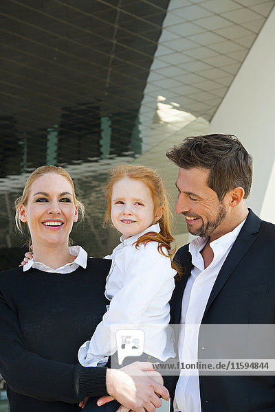 Smiling businessman and businesswoman with girl