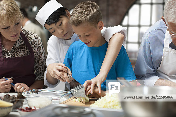 Female chef instructing boy in cooking class