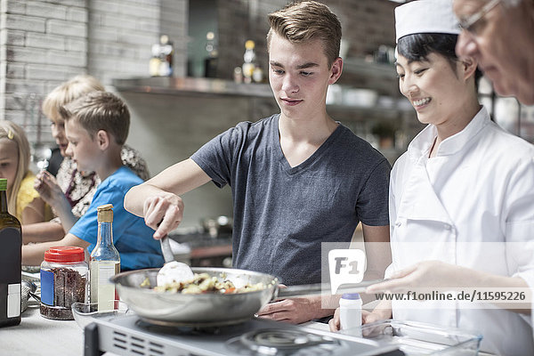Teenager und Köchin beim gemeinsamen Kochen