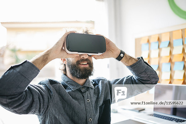Mann mit Virtual Reality Brille bei der Arbeit an einem neuen Projekt in seinem Büro