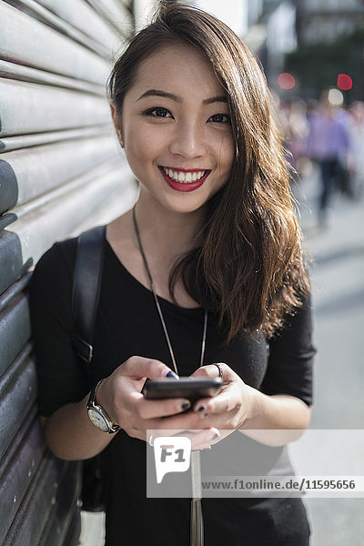 Portrait of smiling young woman with cell phone