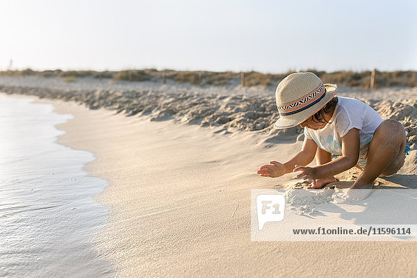 Spanien  Menorca  kleines Mädchen beim Spielen am Strand
