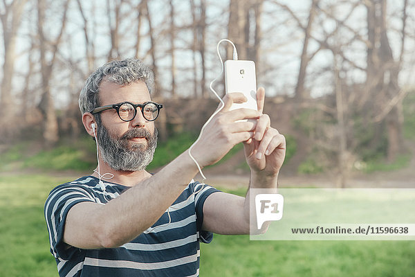 Bärtiger Mann nimmt Selfie mit Smartphone