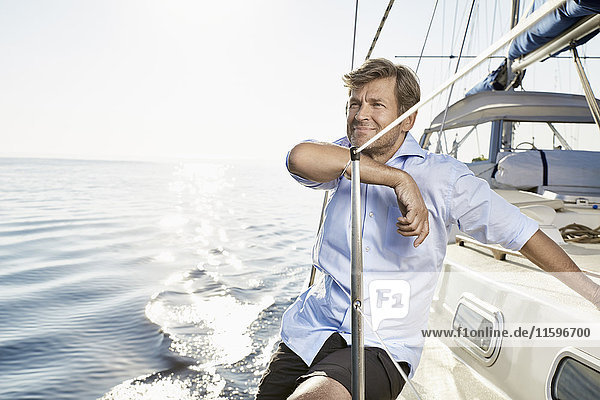 Porträt eines lächelnden reifen Mannes auf seinem Segelboot