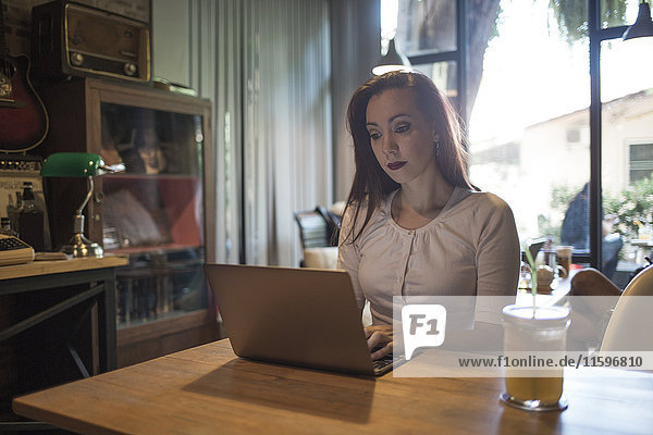 Frau mit einem Laptop in einem Café